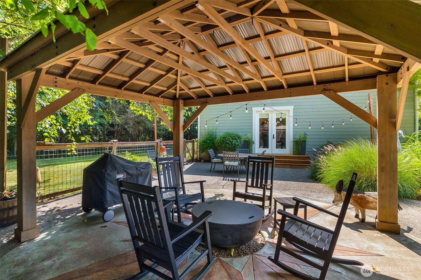 9044 Hunter Point Road Northwest Olympia, WA 98502 - Photo 32 of 40 a view of a chairs and table in the patio and a backyard