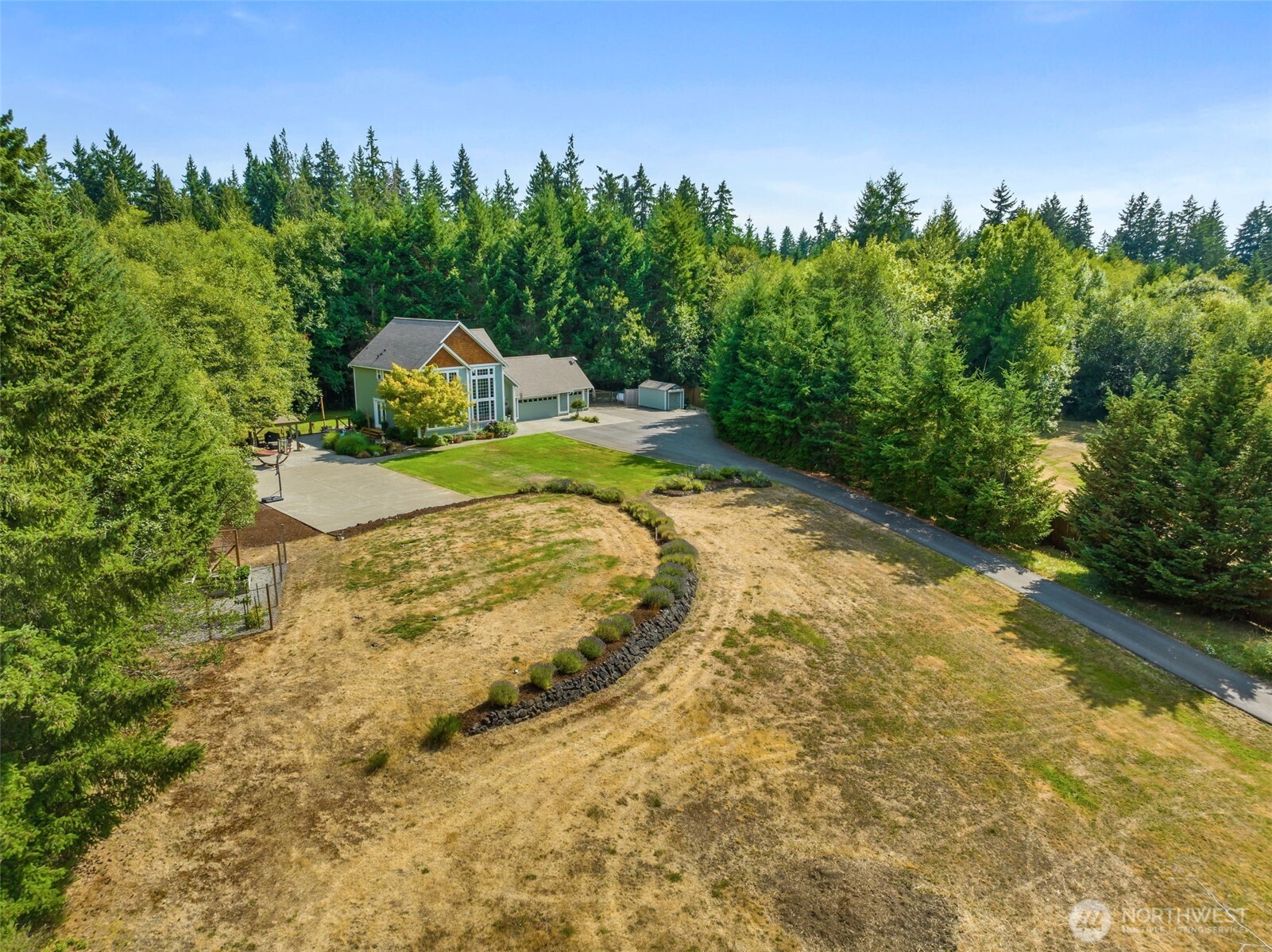 9044 Hunter Point Road Northwest Olympia, WA 98502 - Photo 35 of 40 a view of a yard with swimming pool and trees in the background