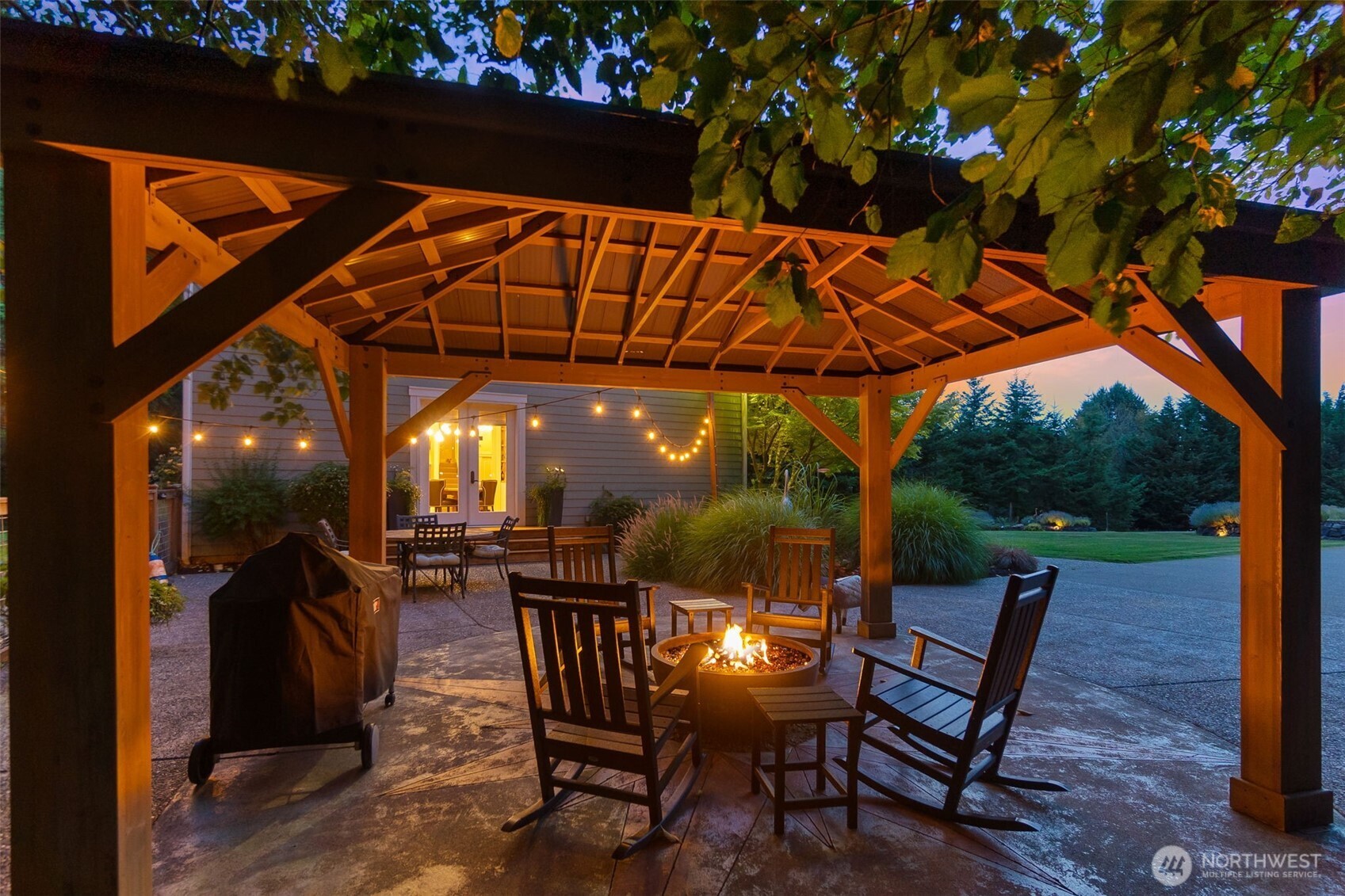 9044 Hunter Point Road Northwest Olympia, WA 98502 - Photo 38 of 40 a patio with wooden floor a yard a table and chairs