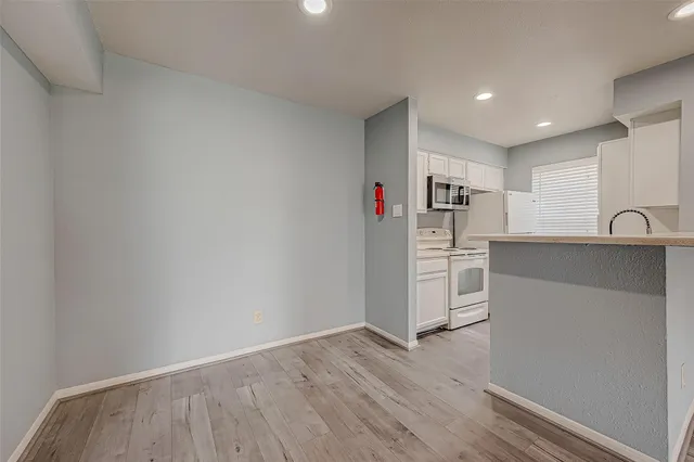 a view of a kitchen with wooden floor and electronic appliances