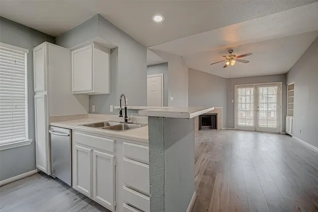 a kitchen with a sink dishwasher a stove and a refrigerator with wooden floor