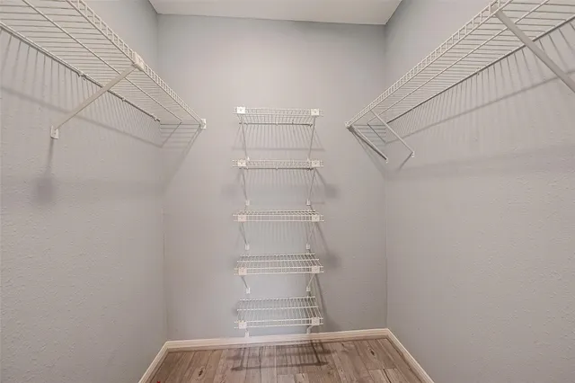 a view of walk in closet with empty racks