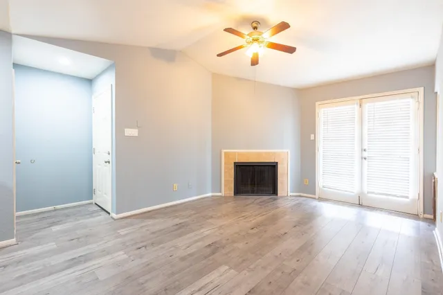 a view of an empty room with a window and a fireplace