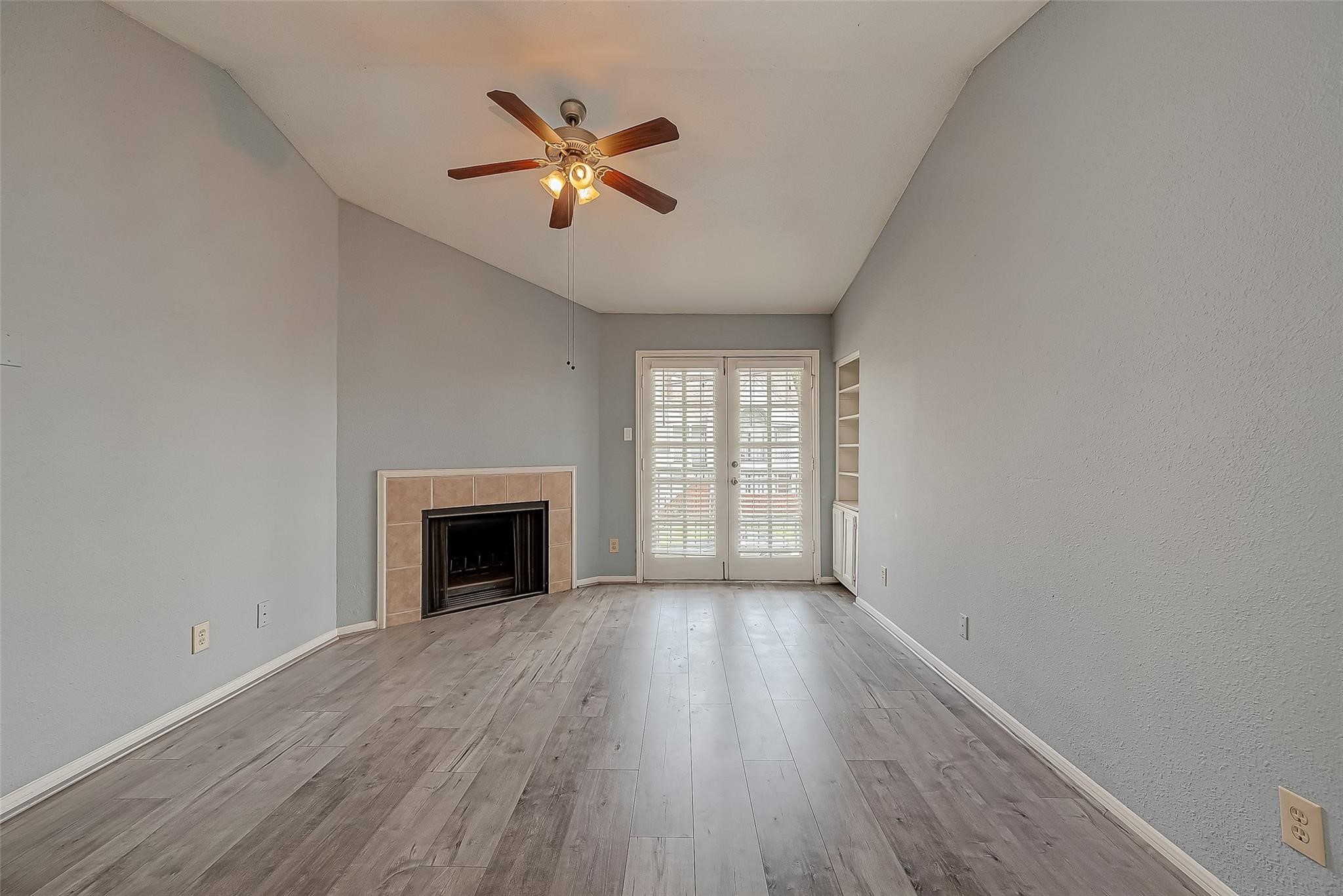 14600 Fonmeadow Drive, Unit 107 Houston, TX 77035 - Photo 6 of 27 an empty room with windows fireplace and wooden floor