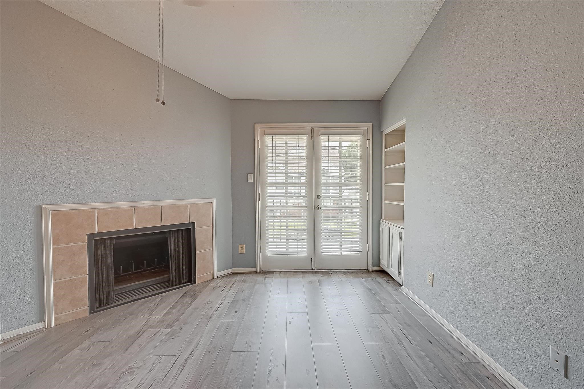 14600 Fonmeadow Drive, Unit 107 Houston, TX 77035 - Photo 7 of 27 an empty room with wooden floor fireplace and windows