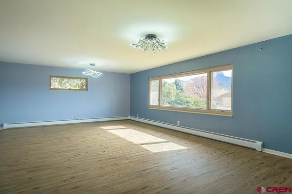 a view of a hallway with kitchen and wooden floor