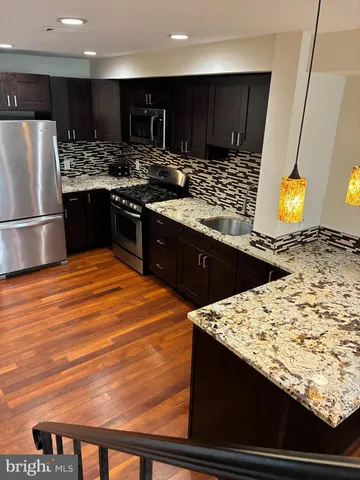 a kitchen with stainless steel appliances kitchen island granite countertop a stove and a sink