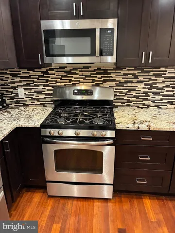 a kitchen with stainless steel appliances granite countertop a stove and a microwave