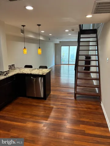 a kitchen with stainless steel appliances granite countertop a stove and a wooden floor