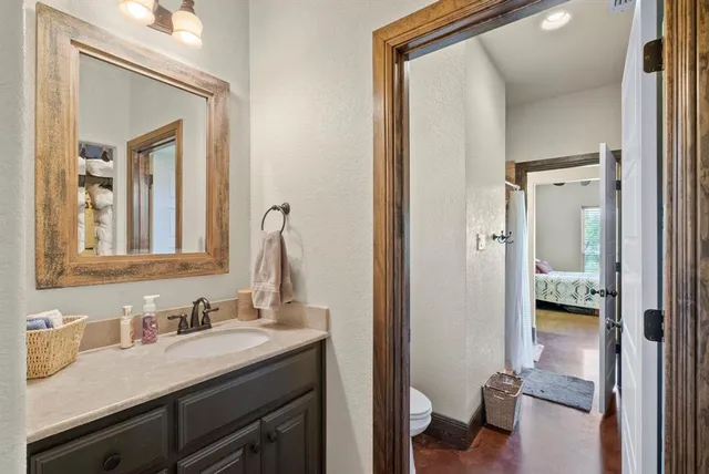 a en suite bathroom with a granite countertop sink mirror and a