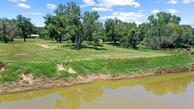 a view of a lake with a yard and swimming pool