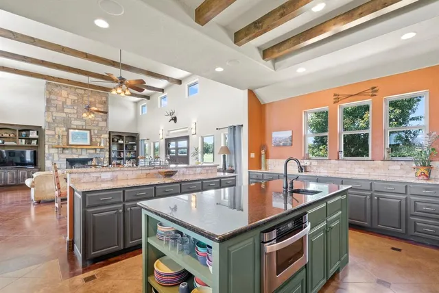 a open kitchen with stainless steel appliances granite countertop a sink and stove
