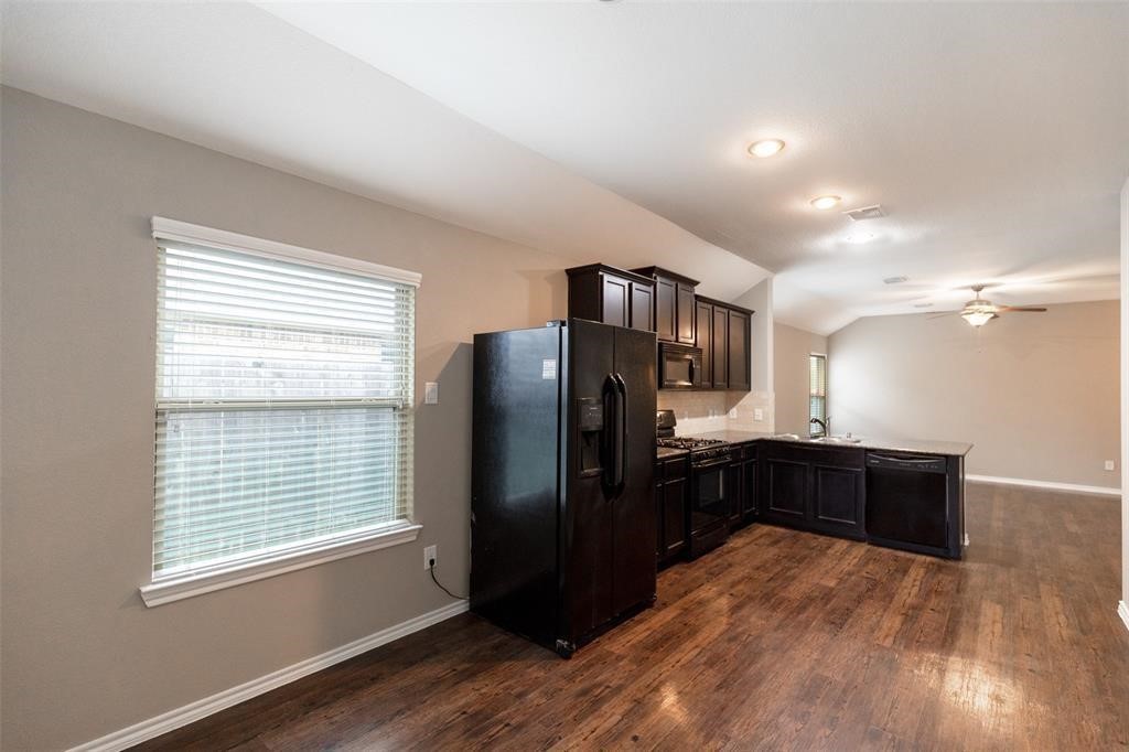 3511 Goldleaf Trail Drive Katy, TX 77449 - Photo 10 of 21 a kitchen with a refrigerator and a wooden cabinets