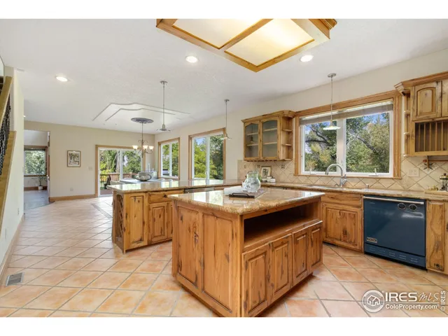 a kitchen with kitchen island granite countertop a sink and wooden cabinets