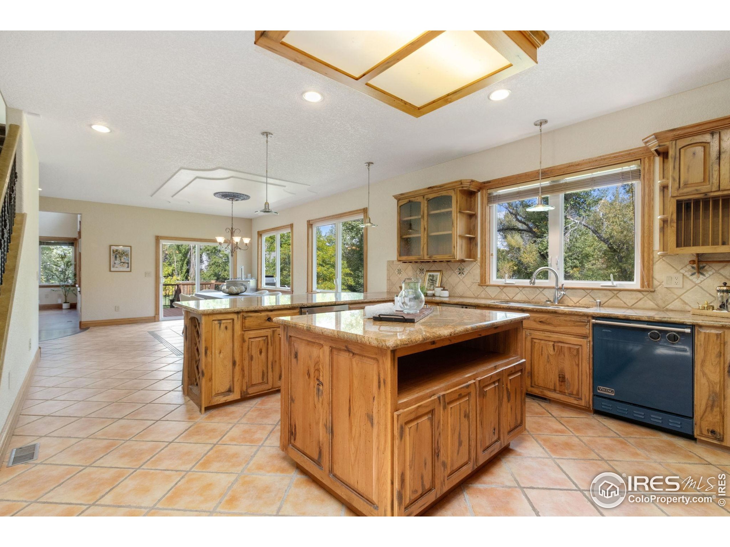 3908 Westfield Court Fort Collins, CO 80526 - Photo 14 of 45 a kitchen with kitchen island granite countertop a sink and wooden cabinets