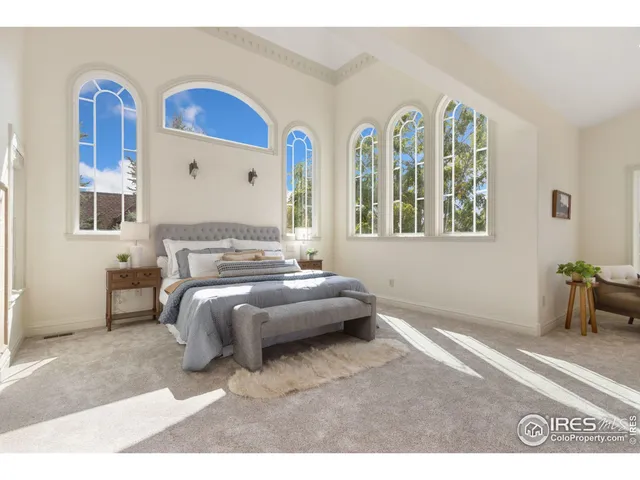 a spacious bedroom with a bed and a painting on the wall