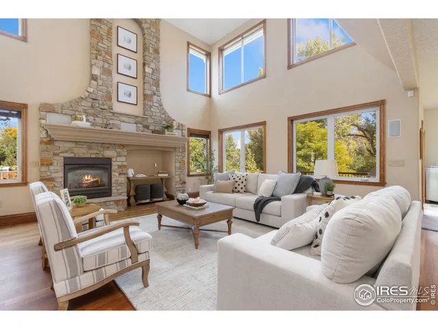a living room with furniture a fireplace and a large window