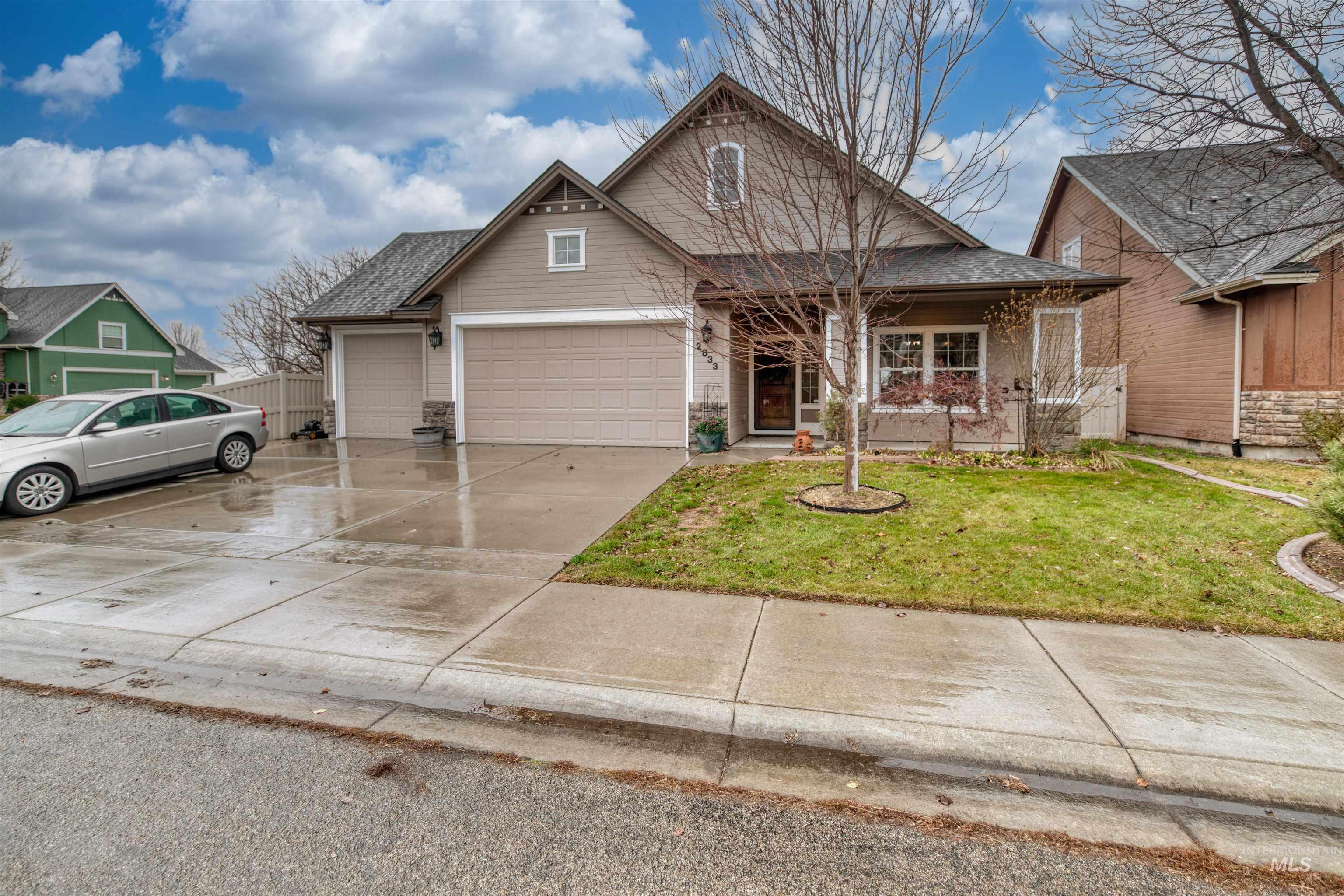 View of front of home featuring a front yard, driveway, an attached garage, covered porch, and a shingled roof
