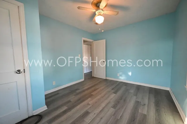 a view of an empty room with wooden floor