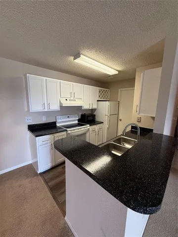 a kitchen with stainless steel appliances granite countertop a sink a stove and a refrigerator