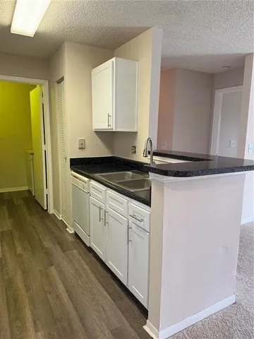 a kitchen with granite countertop white cabinets and white appliances