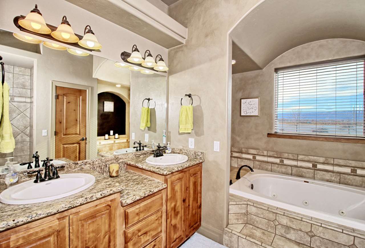 2029 K Road Fruita, CO 81521 - Photo 20 of 39 a bathroom with a granite countertop sink a large mirror and a bathtub