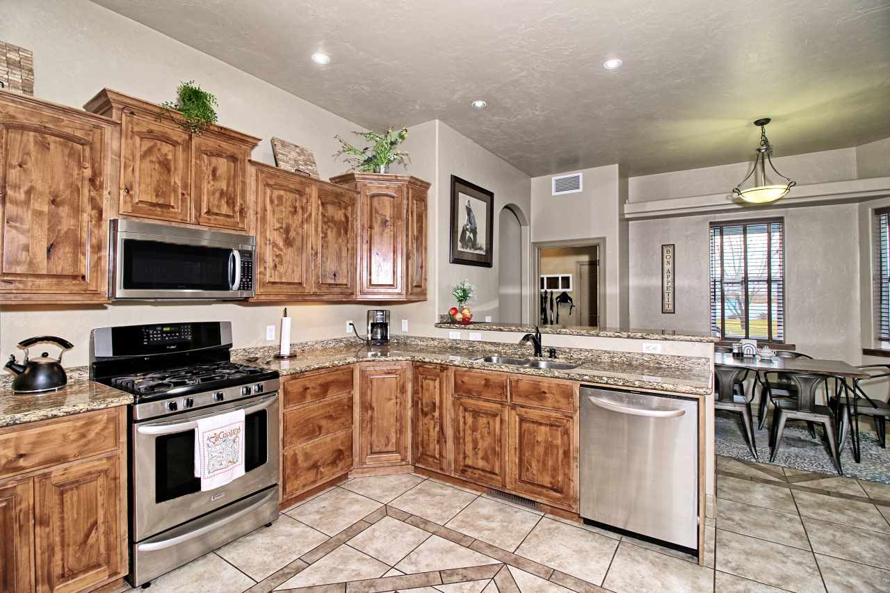 2029 K Road Fruita, CO 81521 - Photo 9 of 39 a kitchen with stainless steel appliances granite countertop a stove top oven a sink dishwasher and white cabinets with wooden floor