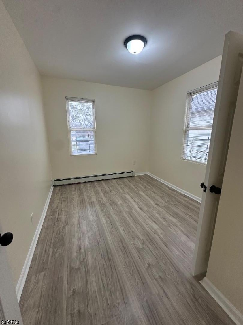 449 3rd Avenue, Unit 2 Elizabeth Port, NJ 07206 - Photo 10 of 11 wooden floor in an empty room with a window
