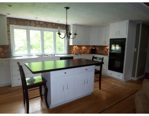 93 Concord Road Chelmsford, MA 01824 - Photo 3 of 18 a kitchen with a table chairs refrigerator and microwave