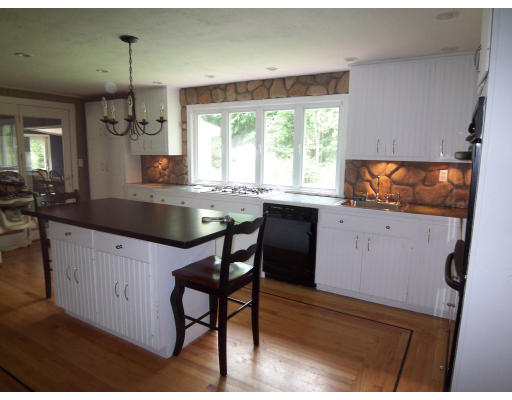 93 Concord Road Chelmsford, MA 01824 - Photo 4 of 18 a kitchen with granite countertop a stove a sink a dining table and chairs