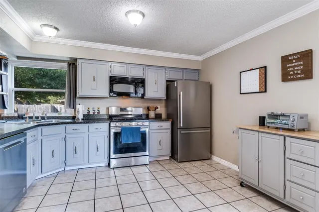 a kitchen with granite countertop a refrigerator stove top oven and sink