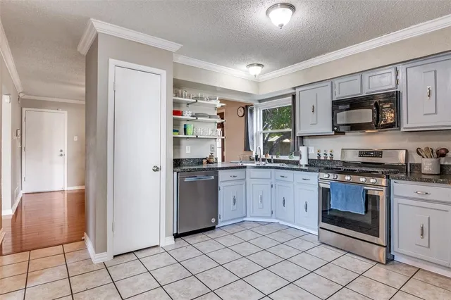 a kitchen with stainless steel appliances granite countertop a refrigerator and a stove top oven