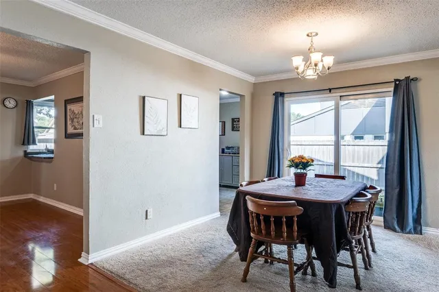 a view of a dining room with furniture a chandelier and wooden floor