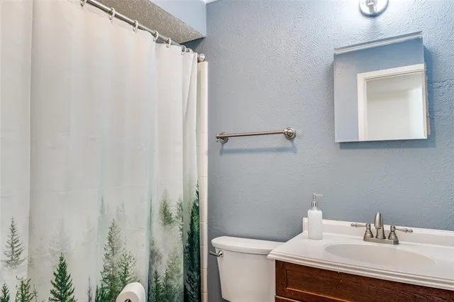 a bathroom with a sink toilet and a mirror