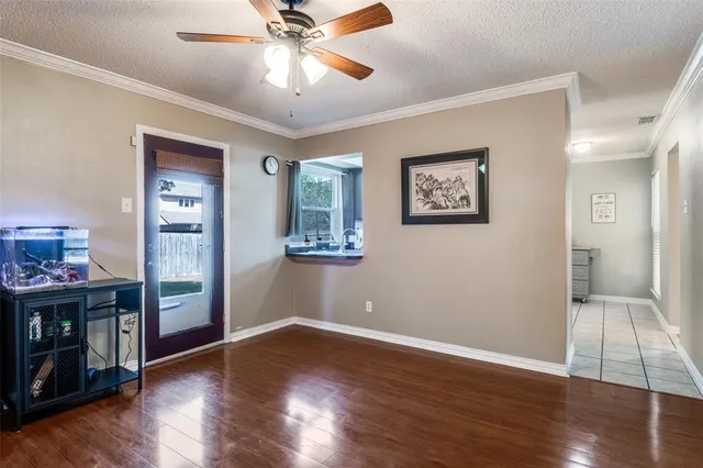 a view of an empty room with window and wooden floor
