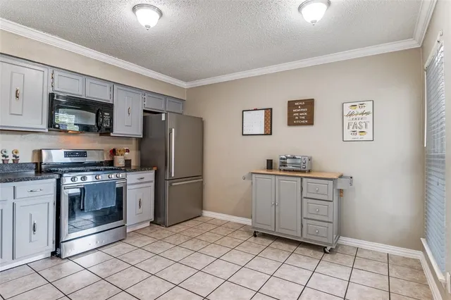 a kitchen with stainless steel appliances granite countertop a refrigerator and a stove top oven