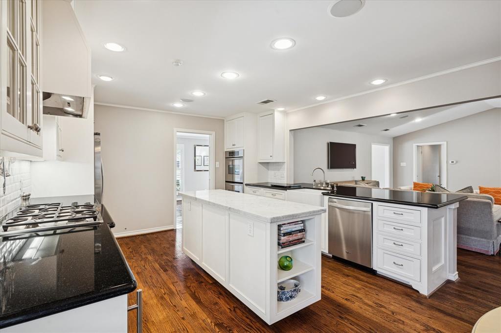 12650 Harriet Circle Dallas, TX 75244 - Photo 10 of 30 a kitchen with stainless steel appliances a stove top oven a sink a refrigerator white cabinets and wooden floor