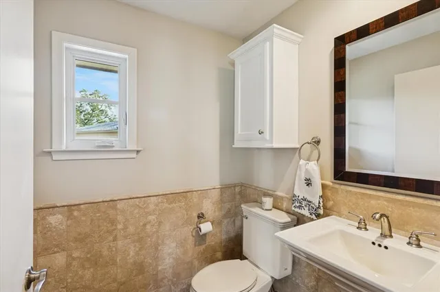 a bathroom with a toilet sink and mirror
