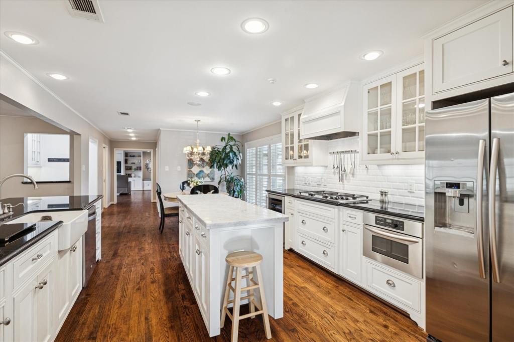 12650 Harriet Circle Dallas, TX 75244 - Photo 2 of 30 a kitchen with white cabinets and stainless steel appliances