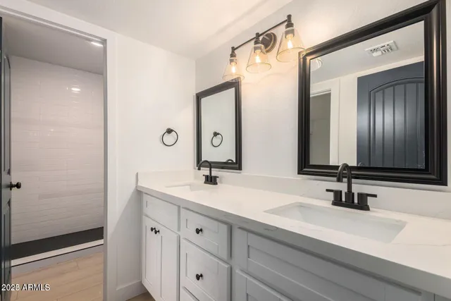 a bathroom with a double vanity sink and mirror