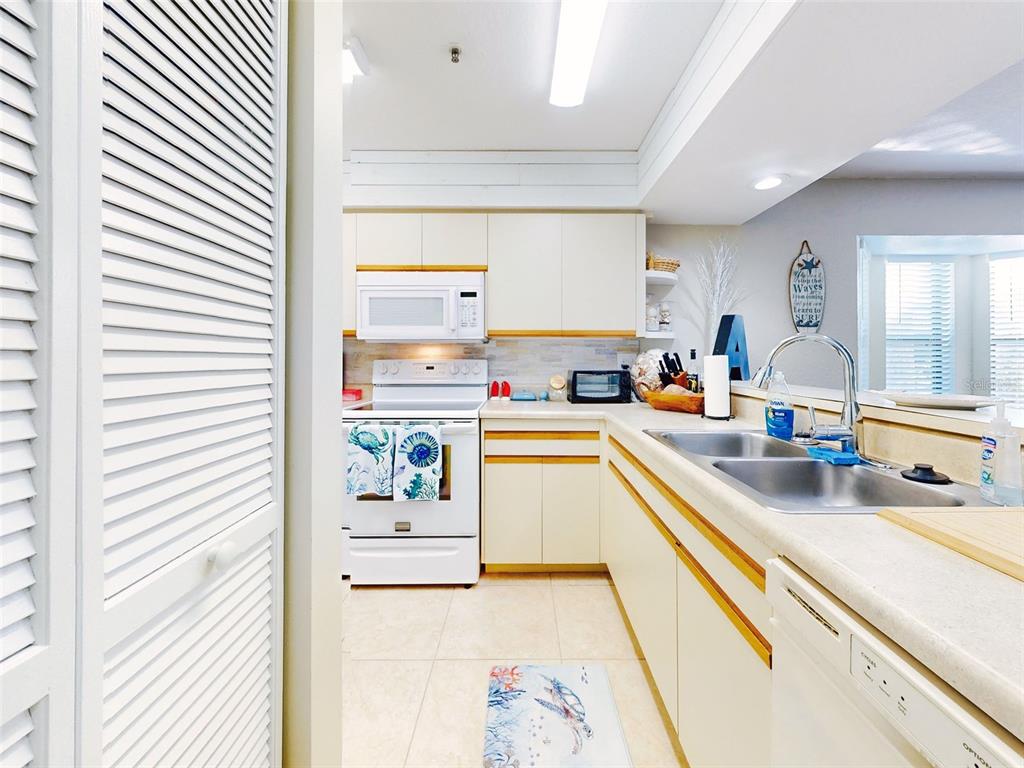 400 Bouchelle Drive, Unit 101 New Smyrna Beach, FL 32169 - Photo 12 of 63 a kitchen with a refrigerator and a sink