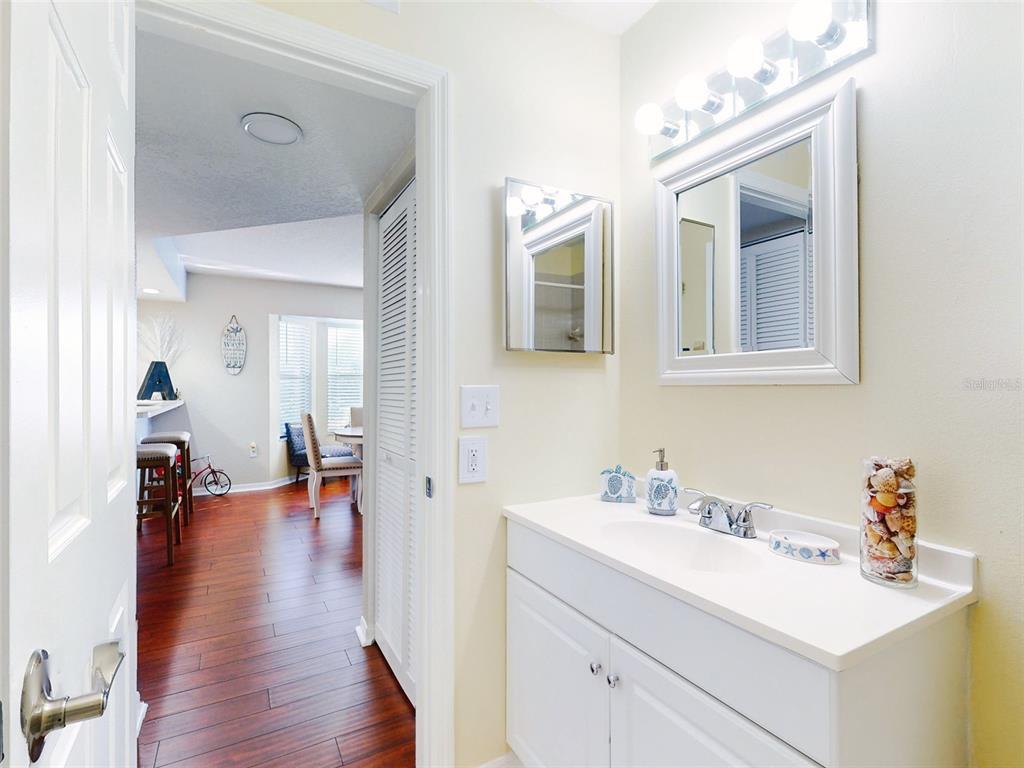 400 Bouchelle Drive, Unit 101 New Smyrna Beach, FL 32169 - Photo 22 of 63 a en suite bathroom with a sink double vanity and wooden floor