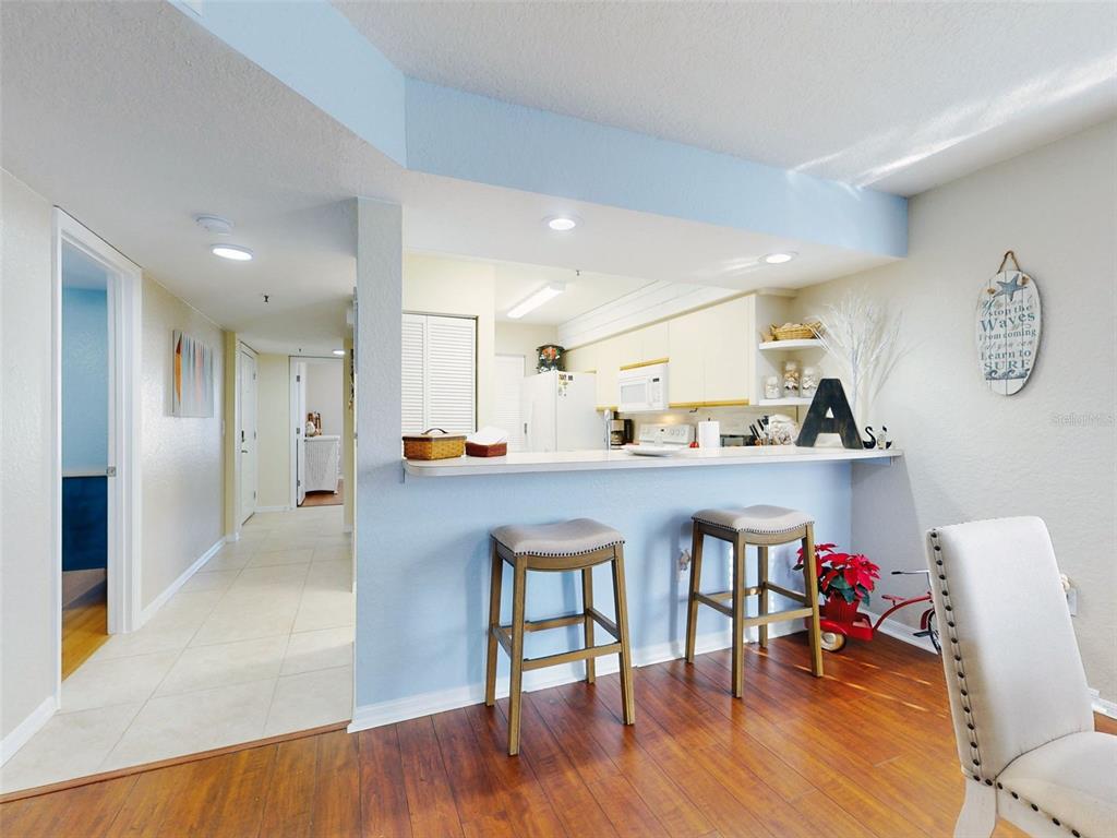 400 Bouchelle Drive, Unit 101 New Smyrna Beach, FL 32169 - Photo 24 of 63 a living room with stainless steel appliances kitchen island a table and chairs
