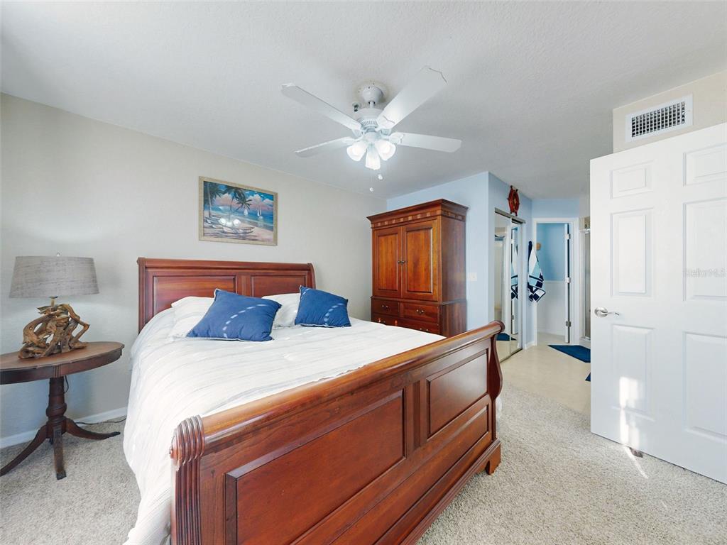 400 Bouchelle Drive, Unit 101 New Smyrna Beach, FL 32169 - Photo 40 of 63 a bed room with a bed and a chandelier