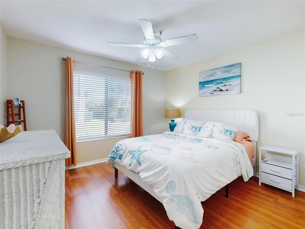 400 Bouchelle Drive, Unit 101 New Smyrna Beach, FL 32169 - Photo 4 of 63 a bedroom with a bed and wooden floor