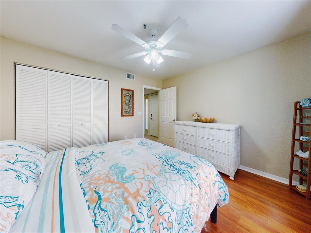400 Bouchelle Drive, Unit 101 New Smyrna Beach, FL 32169 - Photo 6 of 63 a bedroom with a bed and a chandelier