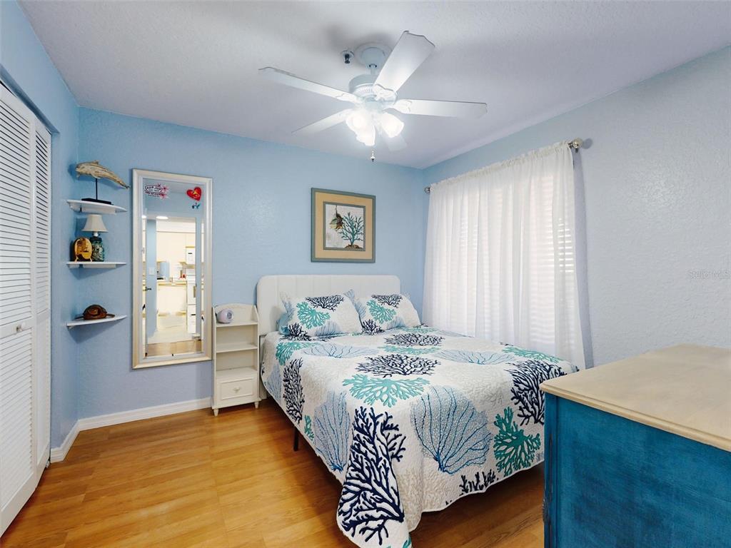 400 Bouchelle Drive, Unit 101 New Smyrna Beach, FL 32169 - Photo 8 of 63 a bedroom with a large bed and a chandelier