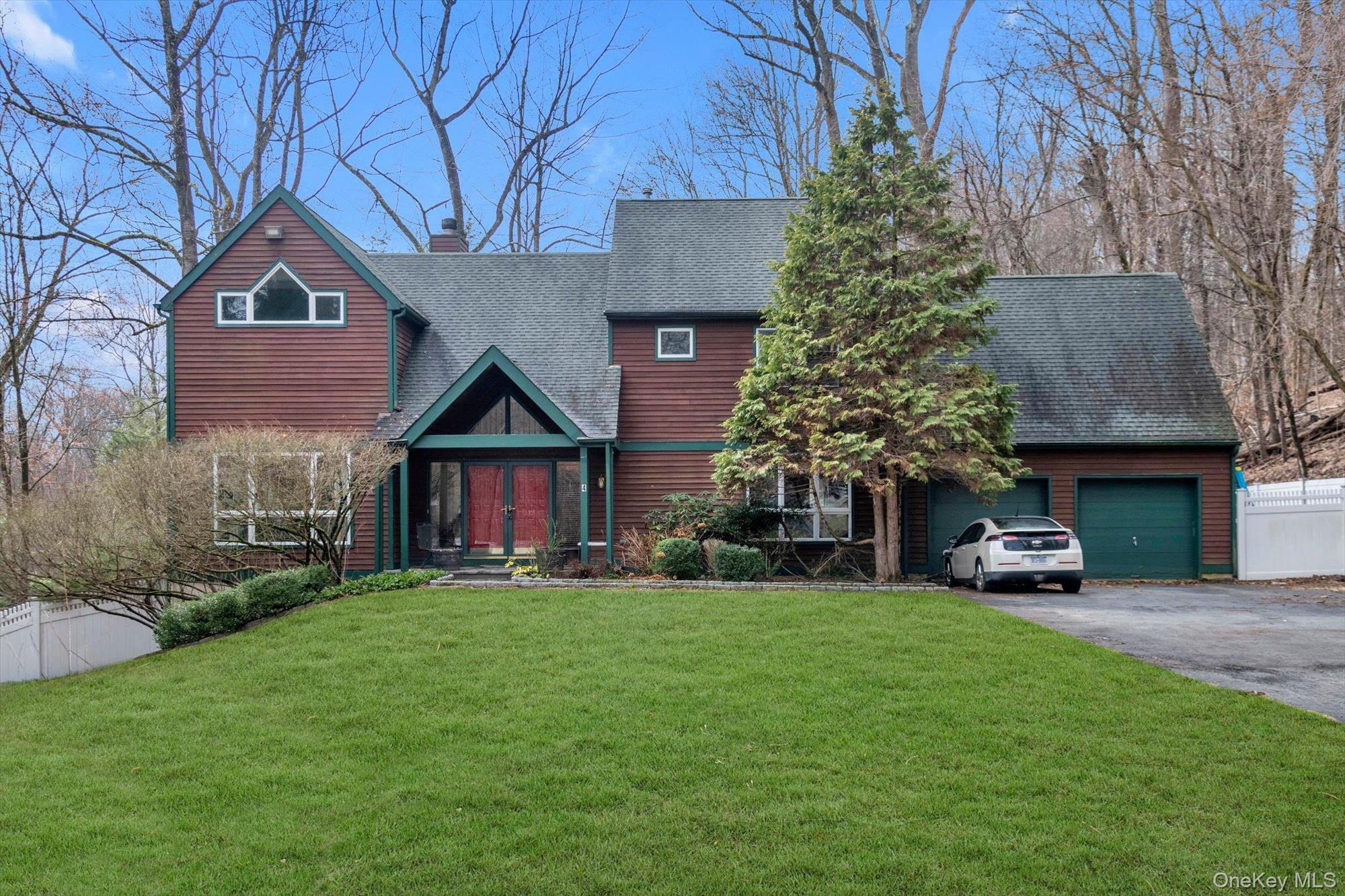 4 Greenlawn Road Cortlandt Manor, NY 10567 - Photo 1 of 26 a front view of a house with a yard and garage