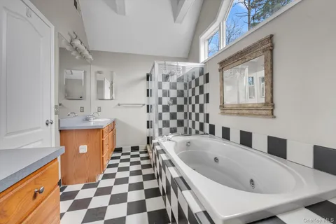 a bathroom with a bathtub sink mirror and shower