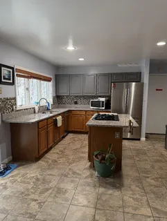 a kitchen with stainless steel appliances granite countertop a stove refrigerator and a sink